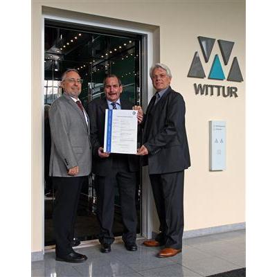 Mr. Karl Weber from TÜV SÜD presents the type examination certificate to Dr. Walter Rohregger and to Mr. Wolfgang Adldinger.